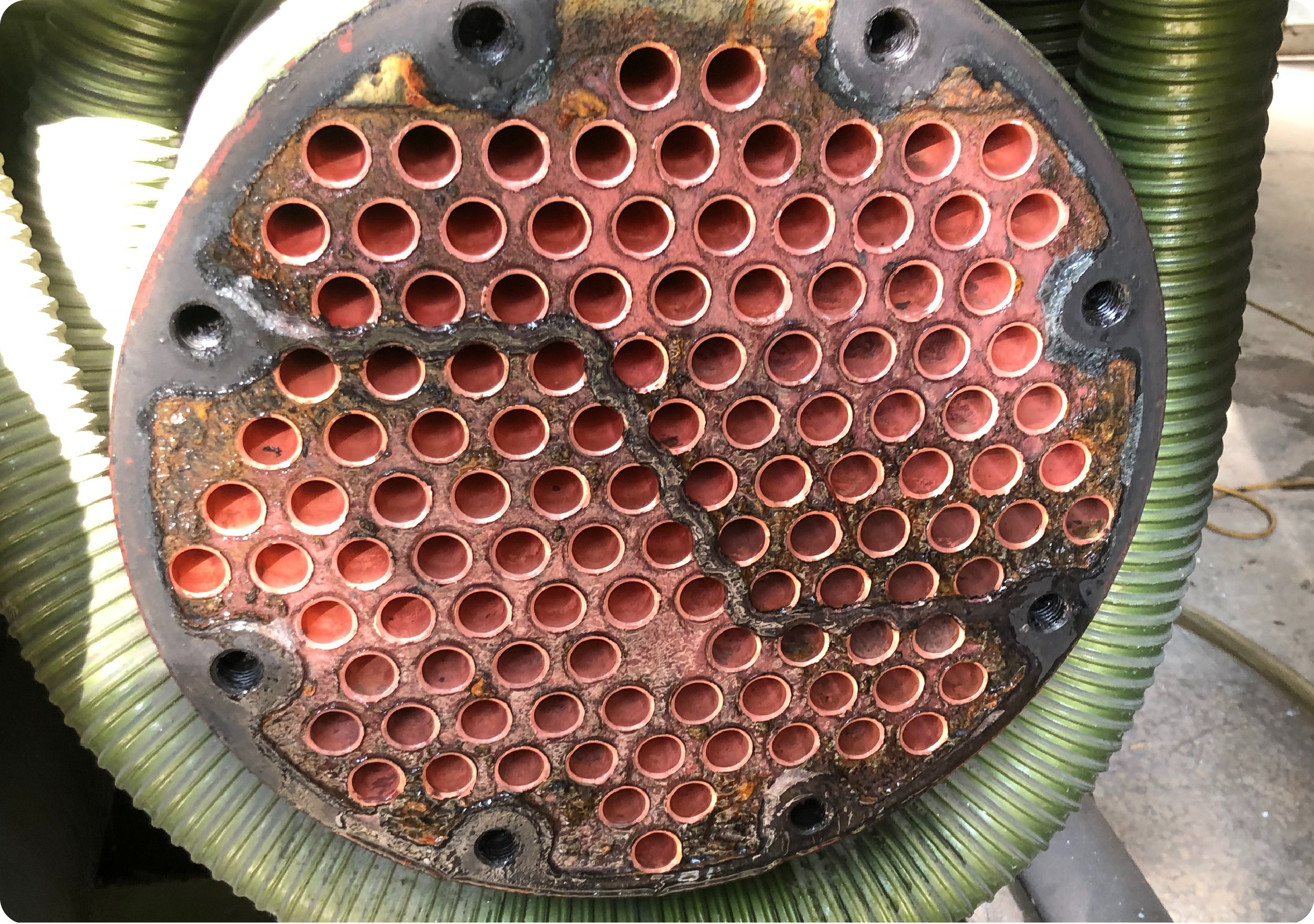 冷凝器使用 SK-199 清洗後，原本被硬垢覆蓋的管束開口恢復，銅管橘紅色金屬面重新顯露，堵塞大幅減少，換熱能力提升