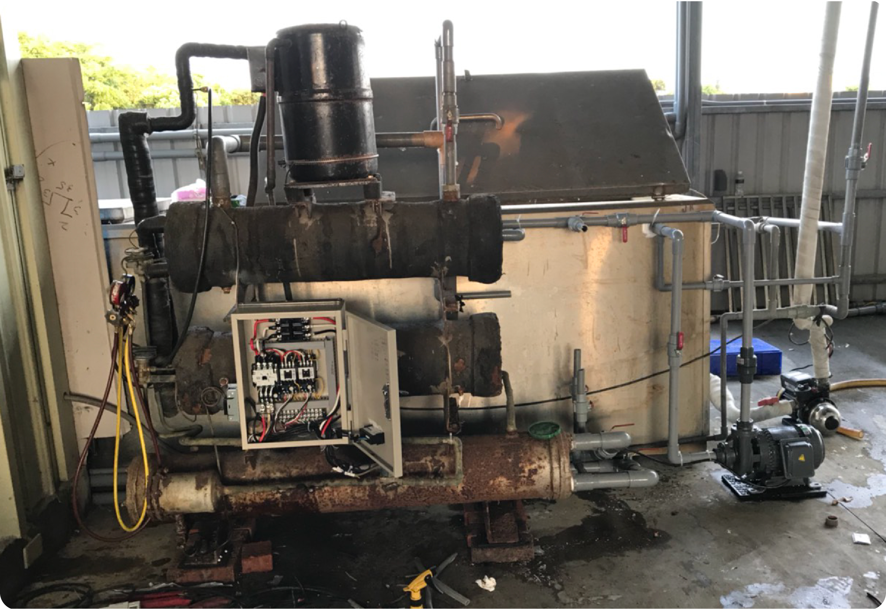 用戶提供冷凝器整機外觀，設備表面可見長期生鏽、泥垢與地下水沉積物累積